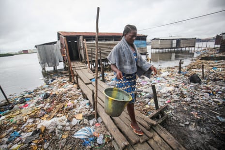 Roselyn Kwesi on her way home after using a bathing and toilet facility that empties straight into the water in Fanti Town, Monrovia, Liberia. 