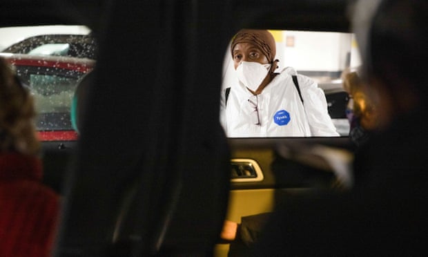 A nurse consults with people waiting in their vehicles to receive Covid vaccines in Detroit, Michigan, on 15 January. 
