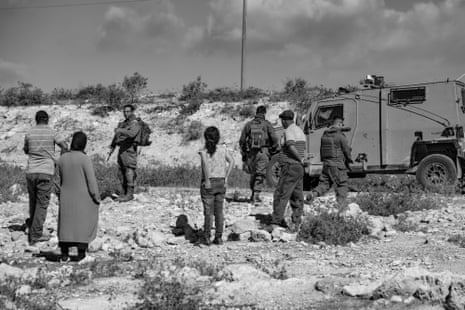 Israeli soldiers forbid harvesting in an olive orchard.