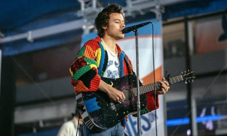 Harry Styles wearing a knitted cardigan while performing on stage