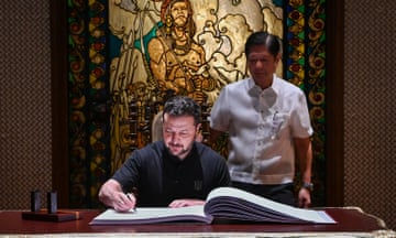 Ukraine’s Volodymyr Zelenskiy signs the guest book beside Philippines' President Ferdinand "Bongbong" Marcos Jr at the Malacanang Palace in Manila on 3 June.