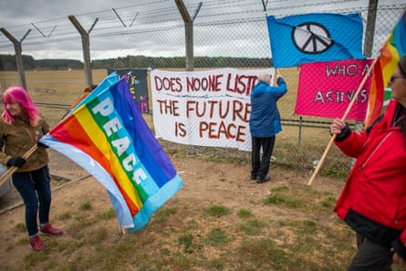 People with banners calling for peace outside fence