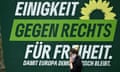 A woman speaks on a mobile phone as she walks past a Green party election poster reading Einigkeit gegen rechts für freiheit (Unity against the right for freedom)