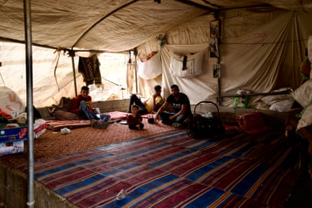 a man and some children sitting in a large Bedouin-style tent