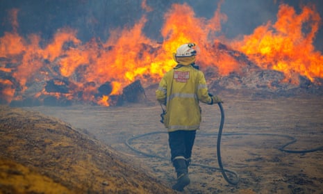 A firefighter battles a blaze in Yanchep, north of Perth, Western Australia, where bushfires were on Sunday threatening lives and homes.