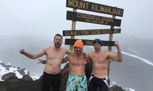 Carney with Wim Hof and a fellow disciple, all bare-chested, linking arm and with fists of defiance, near the summit of Kilimanjaro.