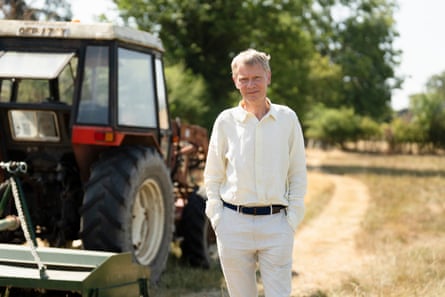 Duncan Fisher stands facing the camera next to a tractor