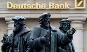 A statue is pictured next to the logo of Germany’s Deutsche Bank in Frankfurt