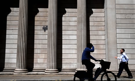 Person cycling past Bank of England.