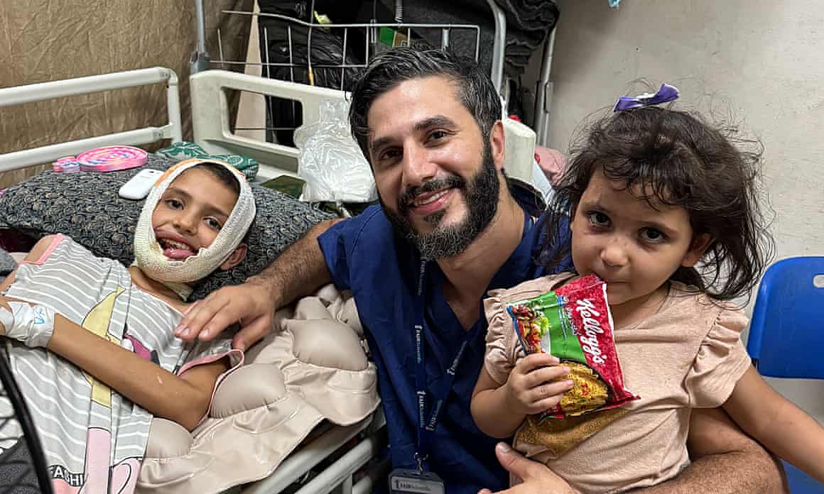 Two children, one bandaged on head with medic