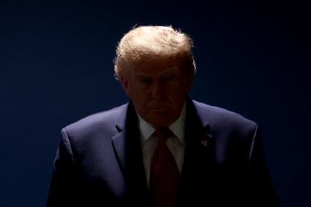 Overhead light illuminates a man’s head, leaving most of him in darkness