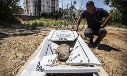 Jamal Abu Kasher, a resident of Lod, looks at one of the several vandalised graves in a Muslim cemetery in Lod, Israel.