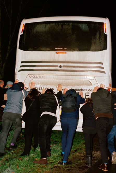 Funeral guests rescuing their bus from the mud.