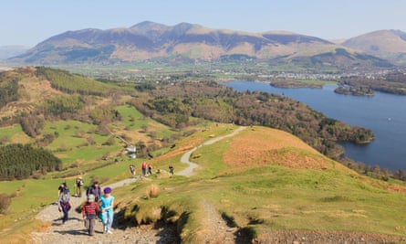 Families walking up Catbells on sunny day with view overlooking Derwent Water