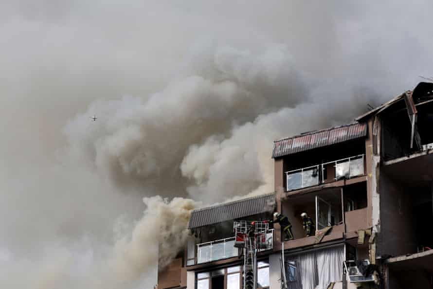 Les pompiers travaillent pour éteindre un incendie dans un immeuble résidentiel touché par un missile russe dimanche matin.