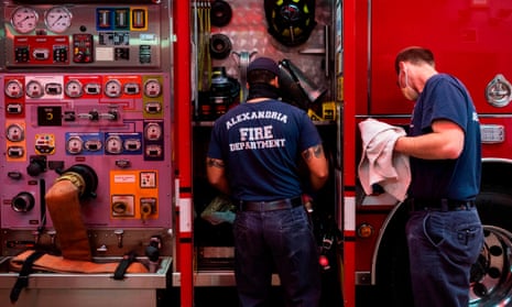 Firefighters Russell Thorone and Darren Hayes clean the outside of the fire engine with a bleach solution at Alexandria Fire Station 204 in Virginia.
