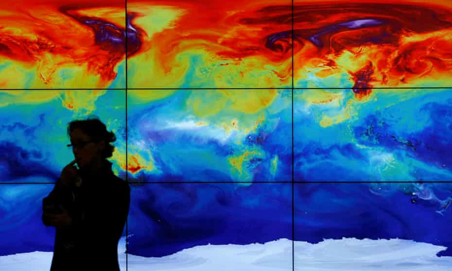 A participant is pictured in front of a screen projecting a world map during the World Climate Change Conference 2015