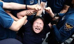 A South Korean protester is detained by police outside the Japanese embassy in Seoul on Thursday after Japan began releasing wastewater from the ruined Fukushima nuclear power plant.