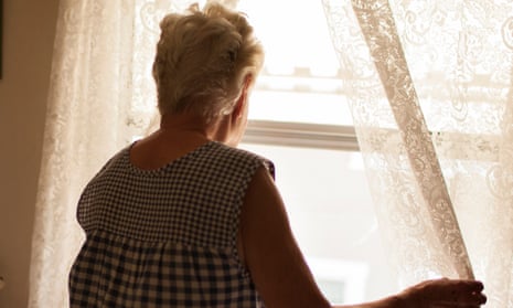 Older woman looking out bedroom window