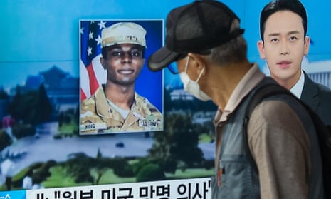 A man walks past a television in Seoul, South Korea, showing a news item about the US soldier Travis King.