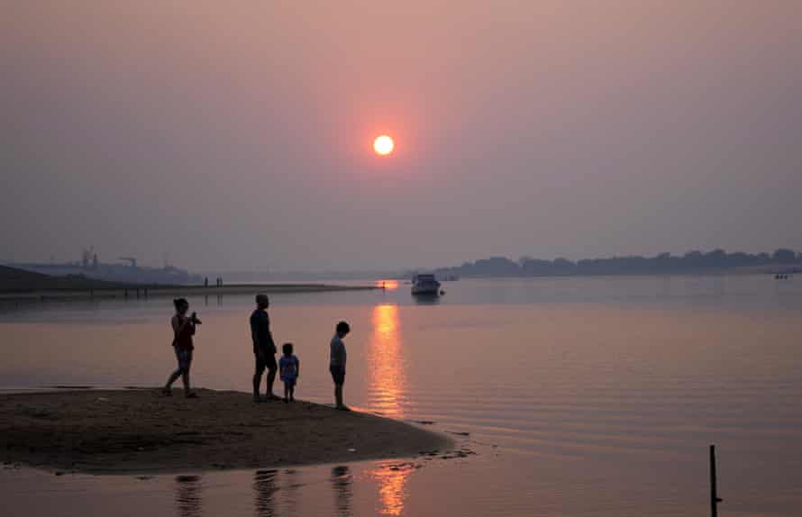 A family stands in the bay connected to the Paraguay River in Asuncion, Paraguay, in August.