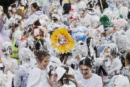 Person wearing ‘sunflower’ headpiece stands out amid group of foam-covered students