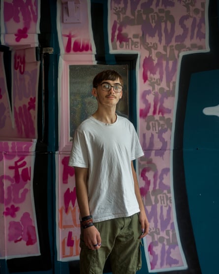 A boy standing in front of wall art.