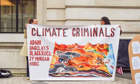 Activists hold a banner calling the companies Adani, Barclays, BlackRock, JP Morgan and HSBC ‘climate criminals’ during the protest outside the Science Museum.