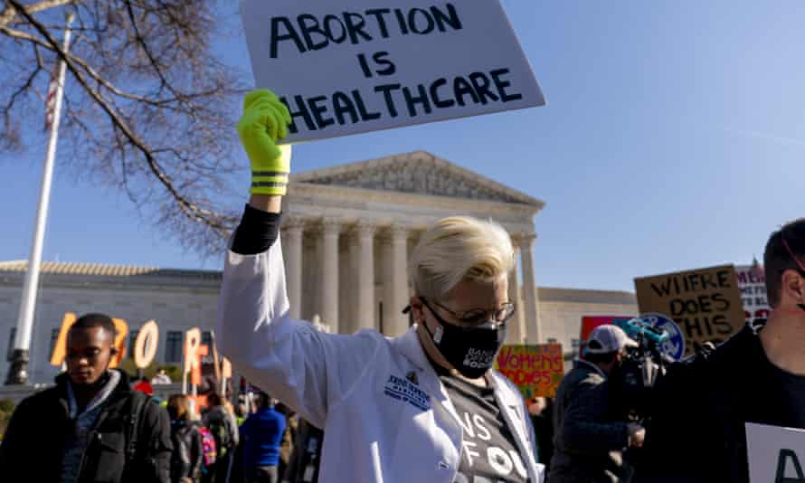A woman holds a poster that reads 'Abortion is Healthcare' as abortion rights advocates and anti-abortion protesters demonstrate in front of the US supreme court