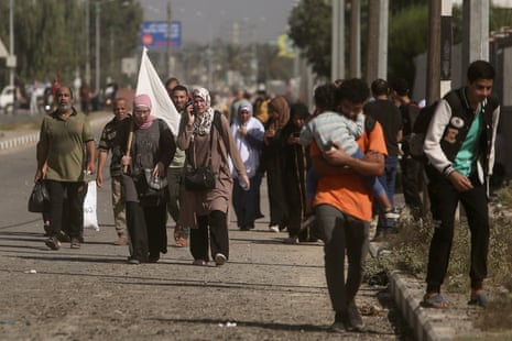 A woman carries a white flag as Palestinians flee Gaza City to the southern Gaza Strip.