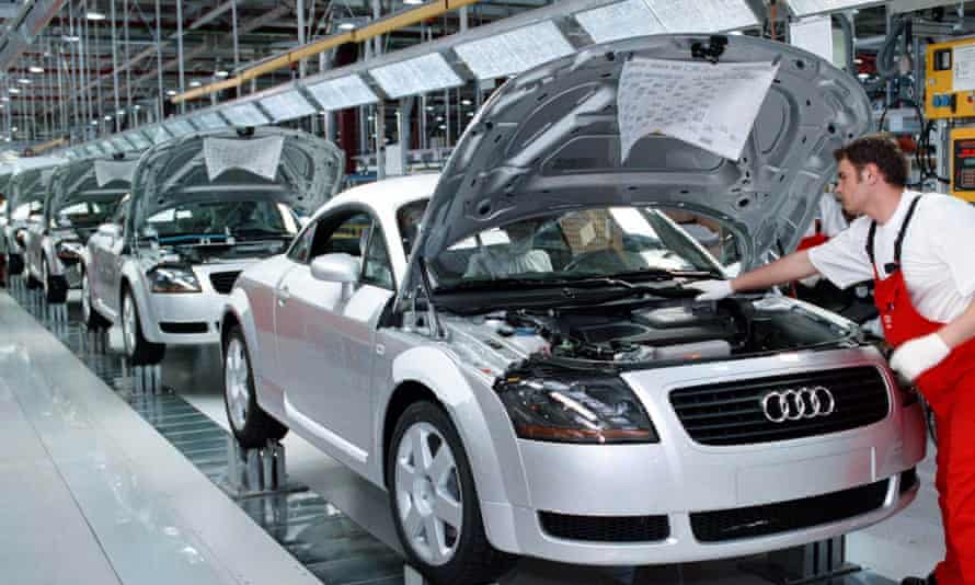 A worker checks the engine compartment of an Audi TT Coupe at the Audi factory in Gyoer, Hungary.