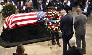 The Senate minority leader, Chuck Schumer, and the South Carolina senator Tim Scott place a wreath at the casket of the late congressman John Lewis.