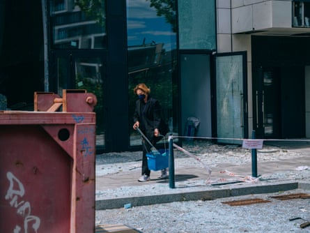 A person wearing a face mask carries a bucket near the scene of the attack