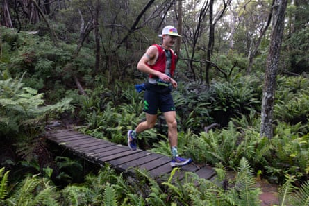 A man runs over a small wooden bridge