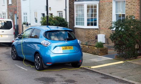 An electric car charging outside a house
