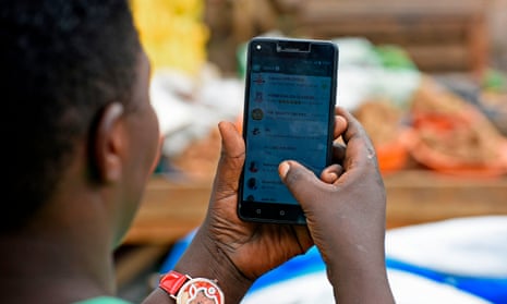 A woman in Kampala scrolls through her WhatsApp messages