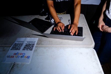 a woman types on a keyboard next to a flyer that says ‘break up with Google’