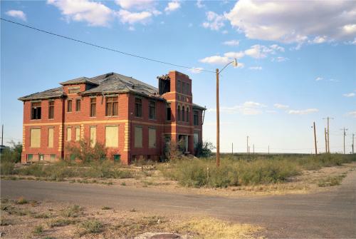 School’s Out, Forever, Toyah, TexasThe old high school in Toyah, Texas stands forlorn in the afternoon heat. On October the 25th , 1906, a black man named J.I Pitts was dragged to death and then hanged for living with his white wife, Eva. In September 1928, Amelia Earhart made an unscheduled five day stop in Toyah to adjust her aircraft’s carburetor. Several youngsters were seen in photos around her plane.