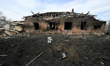 A crater in front of a damaged house after a “massive bombardment” of the village near Bakhmut