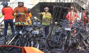 Firefighters clear debris outside the Pentecostal church in Surabaya.
