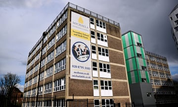 Exterior shot of Michaela community school. There is a sign for the school on the side of a multi-storey building.
