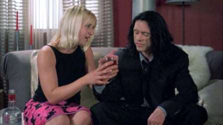 A couple have a drink on a sofa