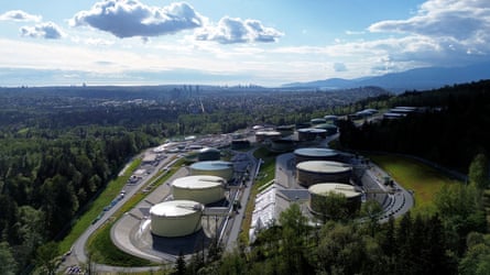 An overhead shot of several oil tanks surrounded by trees