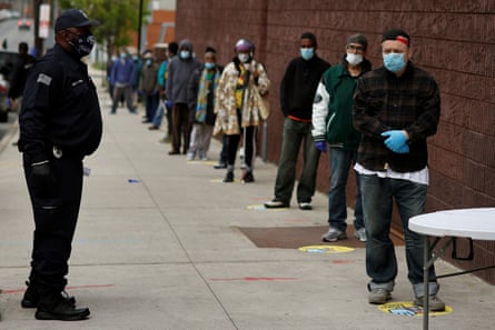 People stand in line to receive bags containing meals, face masks and other personal protective supplies for residents in need outside the NAN Newark Tech World during the outbreak of the coronavirus disease in Newark, New Jersey, U.S.