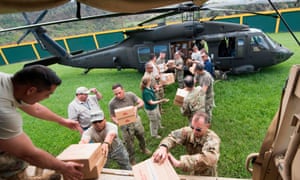 In this image released by the US Department of Defense, Lt Gen Jeff Buchanan, the commander of Joint Task Force Puerto Rico, and soldiers from the Puerto Rico national guard, unload aid supplies from a UH-60 Blackhawk helicopter on Wednesday.