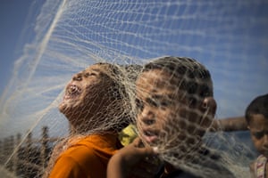 Palestinian boys play with a fishnet on the beach in Gaza City, ahead of the festival of  Eid al-Adha.