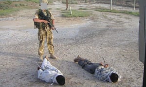 detained Iraqis being guarded by a British soldier