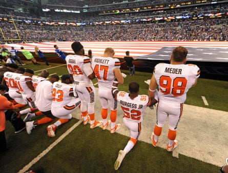 Cleveland Browns players stand and kneel before their game against the Colts at Lucas Oil Stadium in Indianapolis.