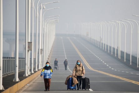 A mother and her son arrive from Hubei province at a checkpoint at the Jiujiang Yangtze River Bridge in January.