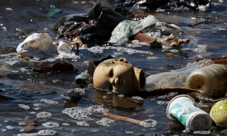 A doll’s head and plastics among the rubbish and untreated sewage in the waters of Guanabara Bay
